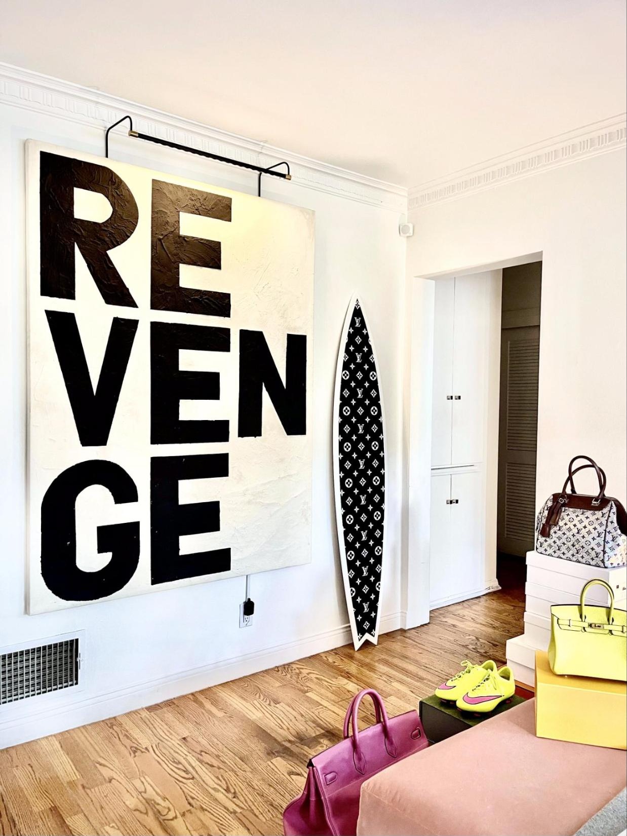 Large black and white text painting reading REVENGE in a client's home